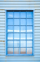 Beautiful glass window blue color and reflections against the sky on wooden background