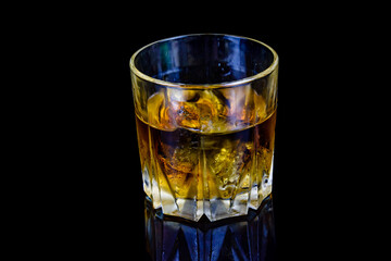 Glass of whiskey isolated on the black background