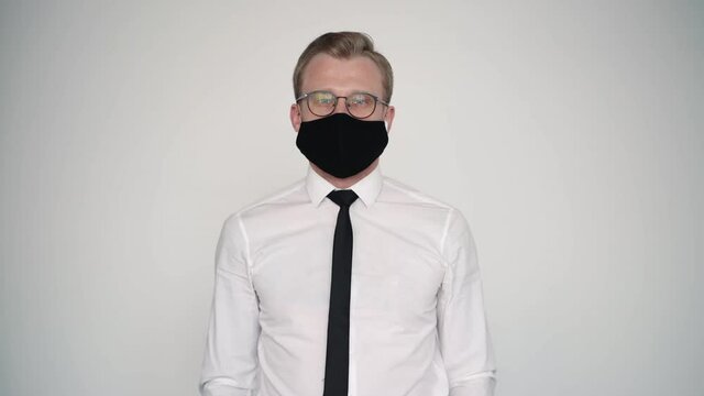 portrait of male office worker wearing whites hirt and mask. standing on wall background. protecting from coronavirus, epidemic, spreading. businessman safety and stop prevent covid-19