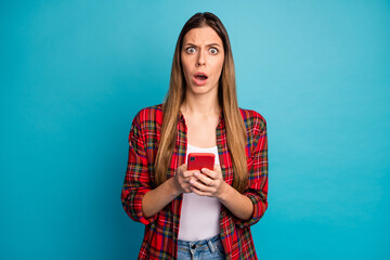 Portrait of her she nice attractive pretty worried long-haired girl wearing checked shirt using cell browsing fake news dislike isolated over bright vivid shine vibrant blue color background