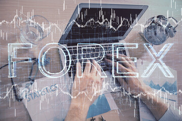Multi exposure of forex graph with man working on computer on background. Concept of market analysis.