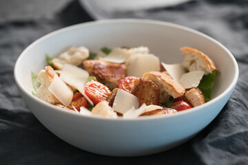 Fresh caesar salad with chicken and cherry tomatoes in white bowl