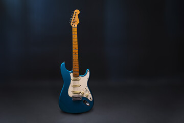 Blue electric guitar on the grey background. 