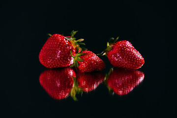 Strawberry on the reflective surface.
