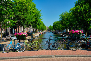 Fototapeta na wymiar Amsterdam canal with boats and bicycles on a bridge