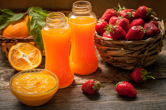 orange juice and ripe strawberries in a basket