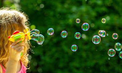 bubble. little girl blowing bubbles in the summer