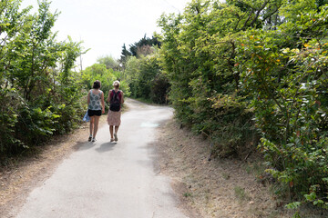women couple go to beach of isle Noirmoutier by sand pathway in Vendee France