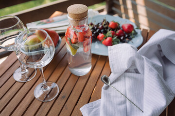 Fresh cool lemonade made of berries, lemon and mint leaves. Summer terrace.