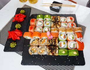 Set of sushi. Different types of Maki and Nigiri sushi with ginger and wasabi sauce. Colorful service at the restaurant.