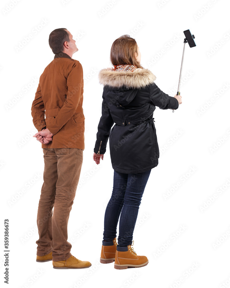 Canvas Prints Back view of couple in winter jacket photographed on a mobile phone in winter jacket.