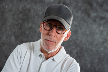 sixty year old man wearing a baseball cap