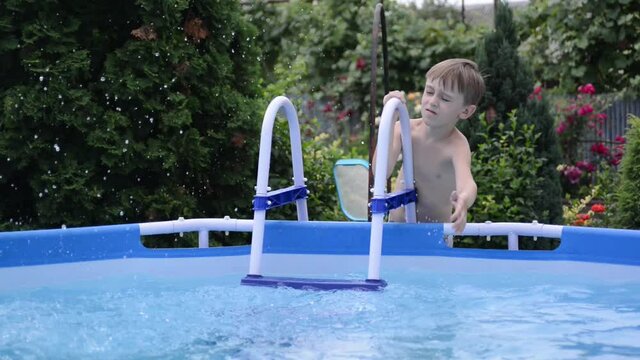 Summer holidays during quarantine. Boy at the pool playing with water. Outdoors home pool.