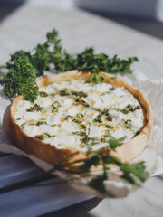 Quiche homemade pie with fresh herbs and feta cheese.