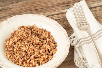 bowl of tasty buckwheat porridge on a wooden table