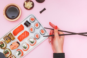 Sushi set with salmon on pink background, top view.