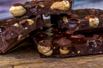 Pieces of black chocolate. Wooden texture background. Sweet food. Food set. High quality photo