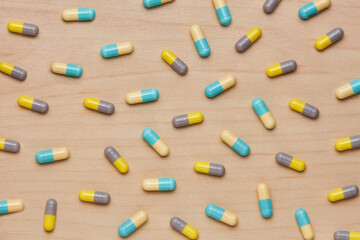 colorful tablets and capsules on wooden background. Health care concept