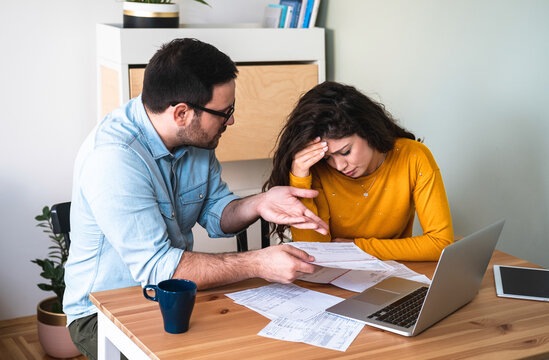 Husband And Wife Fighting Over Money And Expenses, Couple Arguing Over Bills Stock Photo