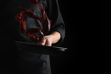 Seafood, chef cooks crayfish on a black background, freeze in motion, recipes, banner