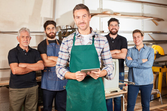 Craftsman trainee in front of carpenter colleagues