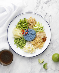 Thai blue rice salad on white marble background. Southern Thai food. 