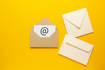Envelope with e-mail symbol on yellow background, concept of corporate communication and marketing...