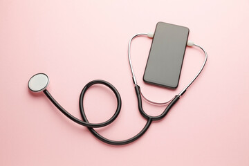 Fototapeta na wymiar Smartphone and stethoscope on pink background. Online medicine (telemedicine) technology. Service for remote diagnostic, chat with doctor.