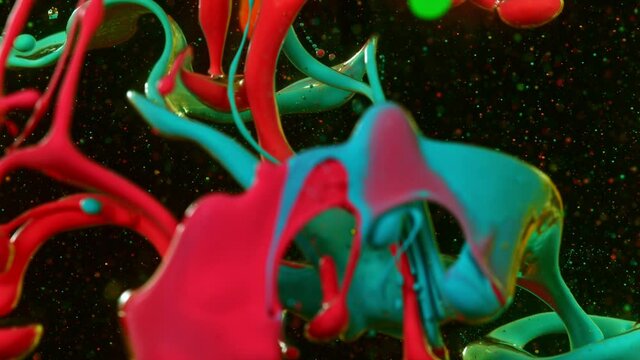 Abstract background, colorful liquid pouring isolated on black background, super slow motion filmed on high speed cinema camera