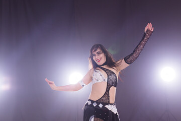 Belly dancer. Young attractive woman dancing tribal fusion on the stage. Oriental exotic dance.