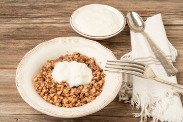 buckwheat porridge served with yoghurt on a wooden table