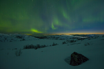 Northern lights over tundra and rocks.Winter landscape.