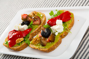 Bread with guacamole, soft cheese, vegetables, herbs