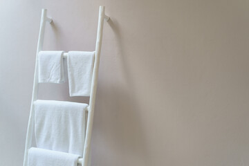 White towel hanging on white wooden stairs stand.