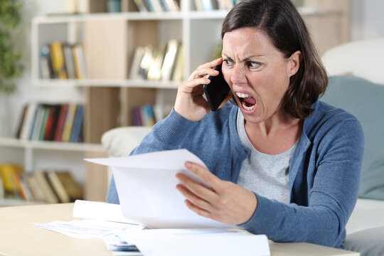 Angry adult woman calling on phone with letter at home