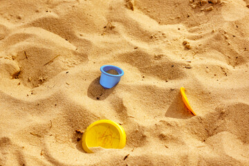 Fototapeta na wymiar wild sand beach with few color plastic toys