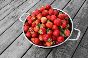 Fresh swedish strawberries during Summer. Bowl standing on an old wooden table. Dessert for Midsummer holiday.