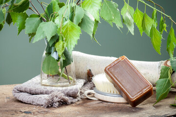 Soap with birch tar. Natural soap
Birch twig with leaves and spring birch catkins, soap on a wooden...