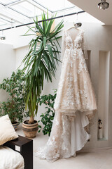 Wedding dress hanging on a hanger.