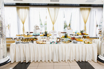 Delicious sweets on candy buffet. Candy bar on wedding ceremony with a lot of different candies.