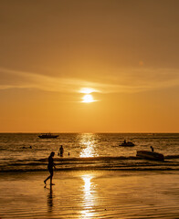Naklejka na ściany i meble silhouette of a sunset ray on the beach