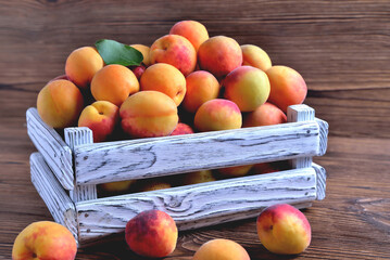 apricots in a white wooden box on a natural wooden brown background