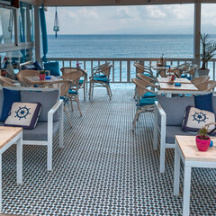 chairs and a table a coastal cafe on the Mediterranean coast in the recreation area of ​​the Greek city of Hersonissos during quarantine COVID-19