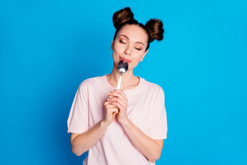 Photo of pretty lovely satisfied lady two funny buns metal knife inside mouth eyes closed try tasty...