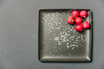red radish on a plate on a dark background