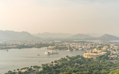 Lake Pichola with City Palace and Aravalli Hills at dawn in Udaipur, Rajasthan, India.