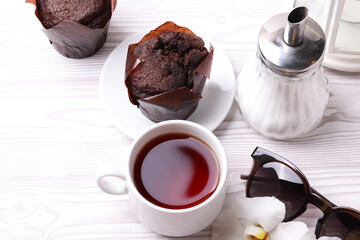 delicious brown chocolate muffin cakes on the white rustic wooden surface. close up. minimalism style
