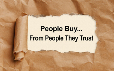 Text People buy from people they trust, appearing from tattered craft paper
