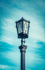 Fototapeta na wymiar Old street lamp against the blue sky in clear weather