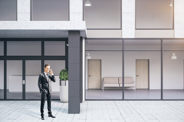 Businessman talking near futuristic office building.